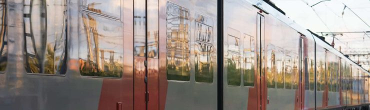 Train arrival: outside view of modern sleepers carriage for suburban or regional travel. Fast intercity locomotive on railroad. Wagon on railway. Transportation infrastructure and tourism concept